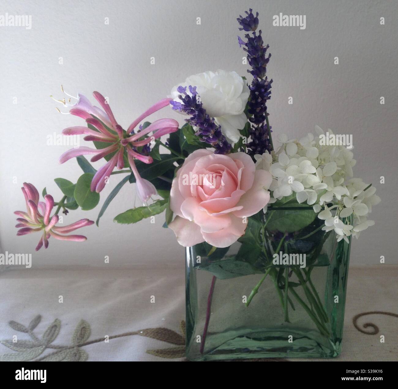 Fleurs roses, violettes et blanches dans un petit vase Banque D'Images