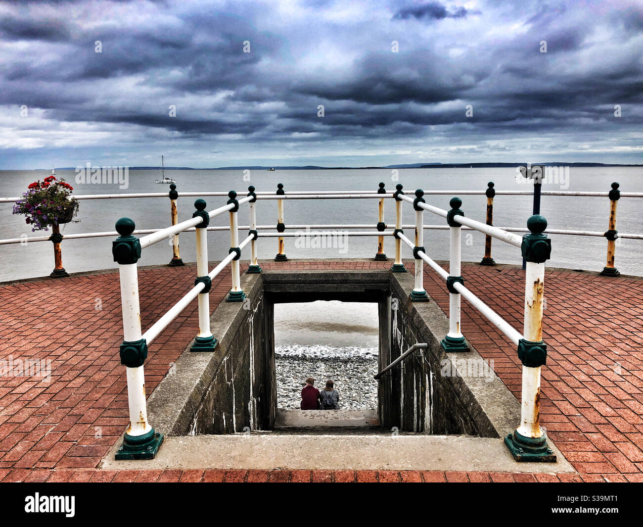 Deux personnes regardant la mer sur la plage de Penarth, septembre. Banque D'Images