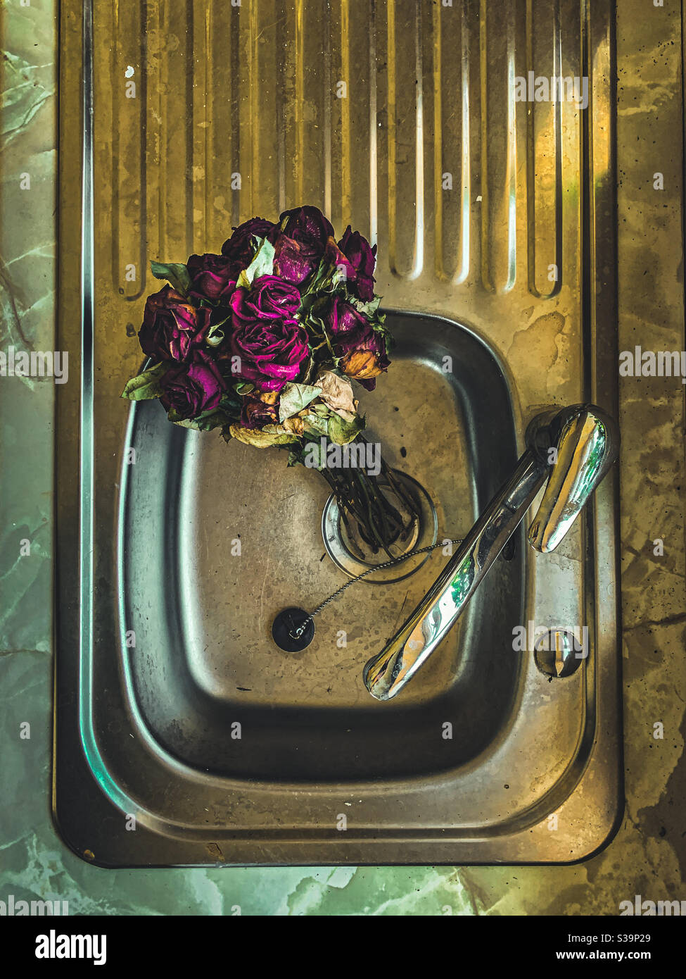 Roses rouges mortes dans un évier - Image de stock capturée avec un smartphone