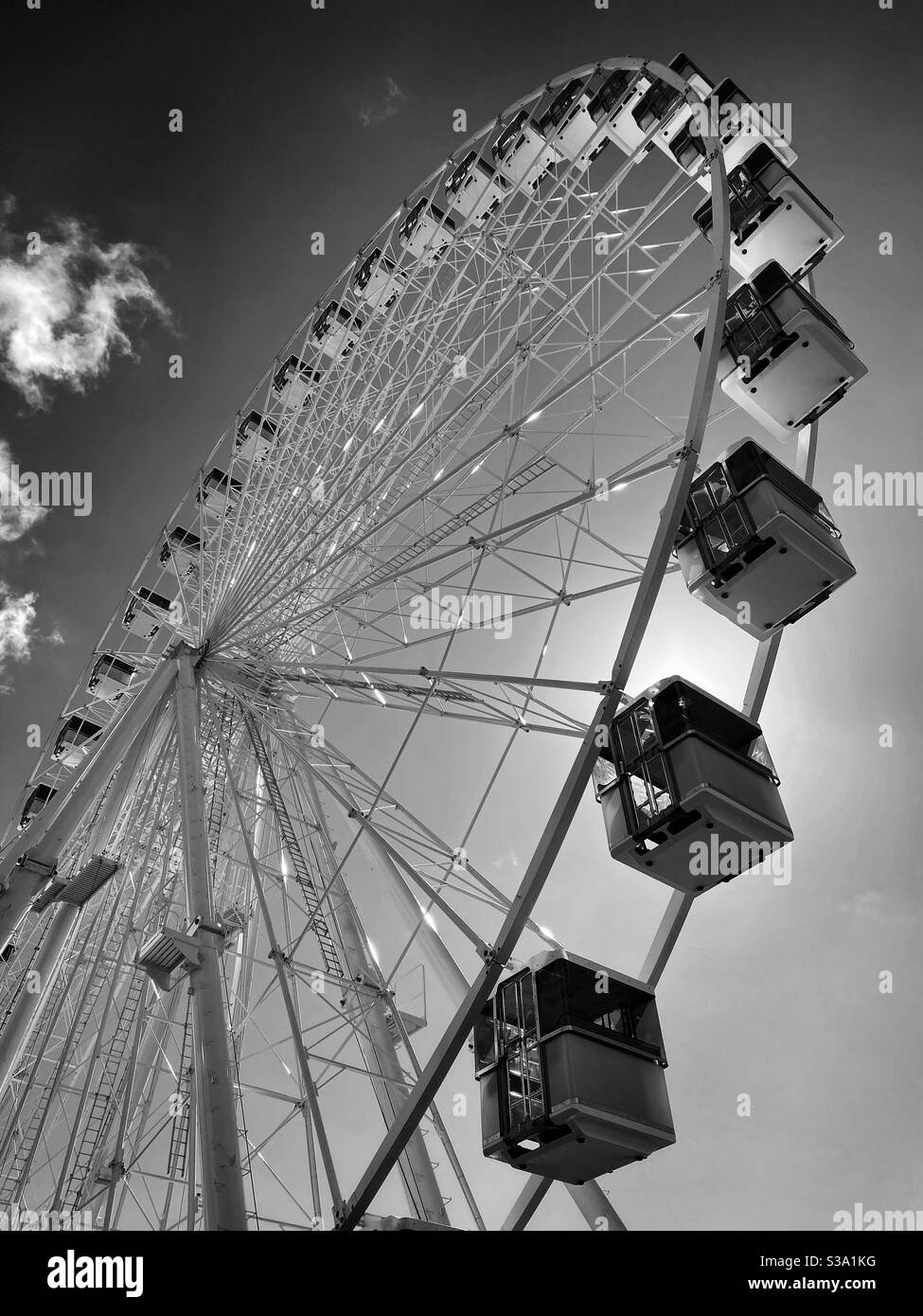 Une grande grande roue tourne lentement dans le soleil d'été quelque part en Europe. Une vue synonyme de vacances, de détente, de plaisir et de soleil. Crédit photo - ©️ COLIN HOSKINS. - Image de stock capturée avec un smartphone