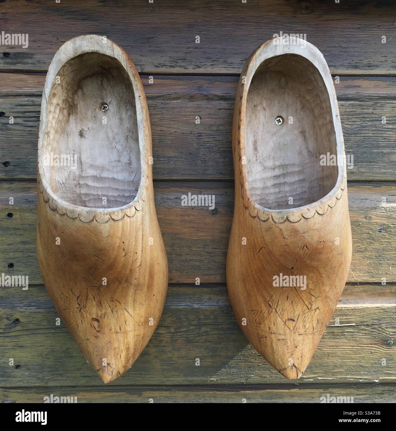 Une paire de vieilles chaussures en bois accrochées au mur d'un hangar  Photo Stock - Alamy