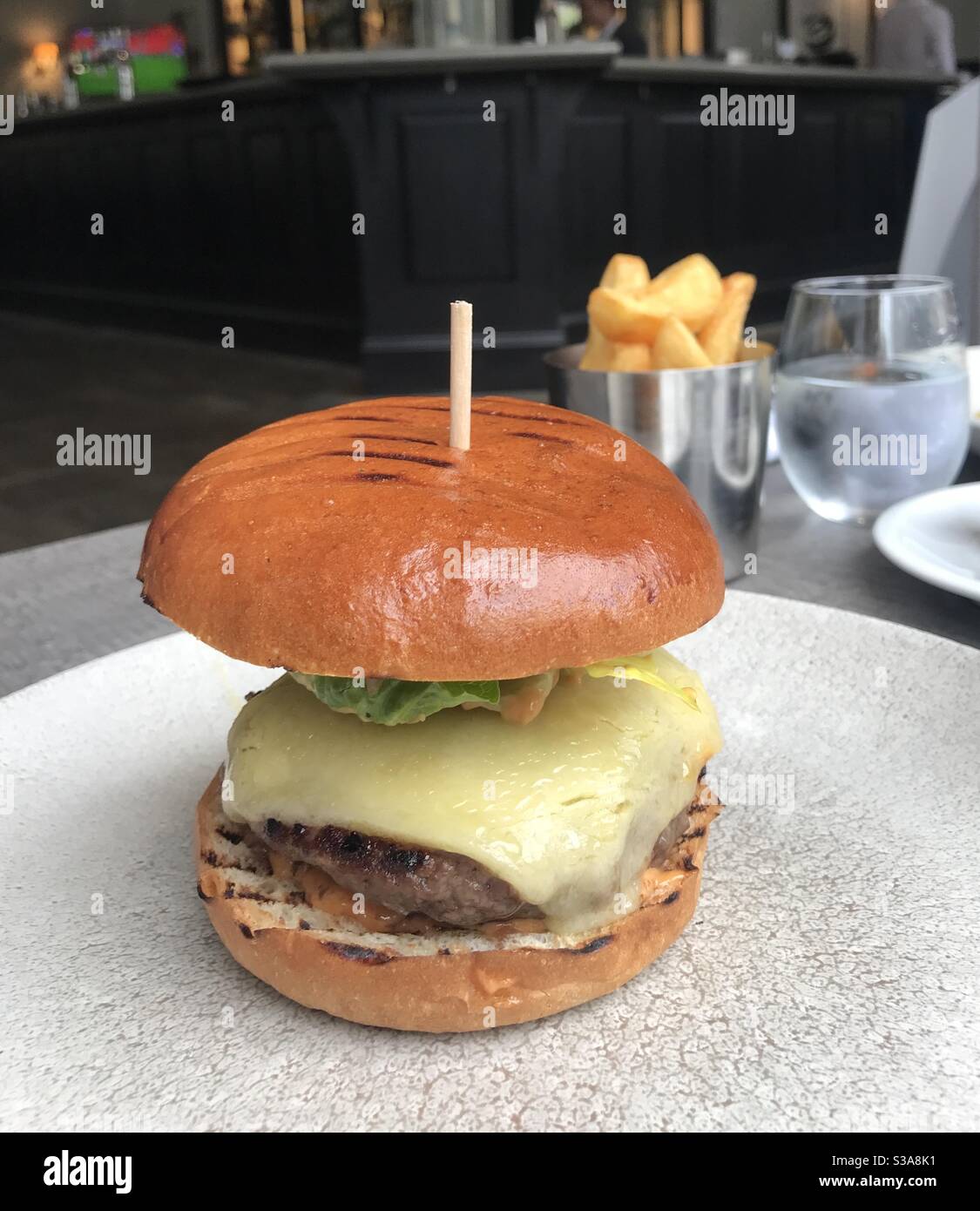 Hamburger gastronomique servi avec un côté de frites Banque D'Images