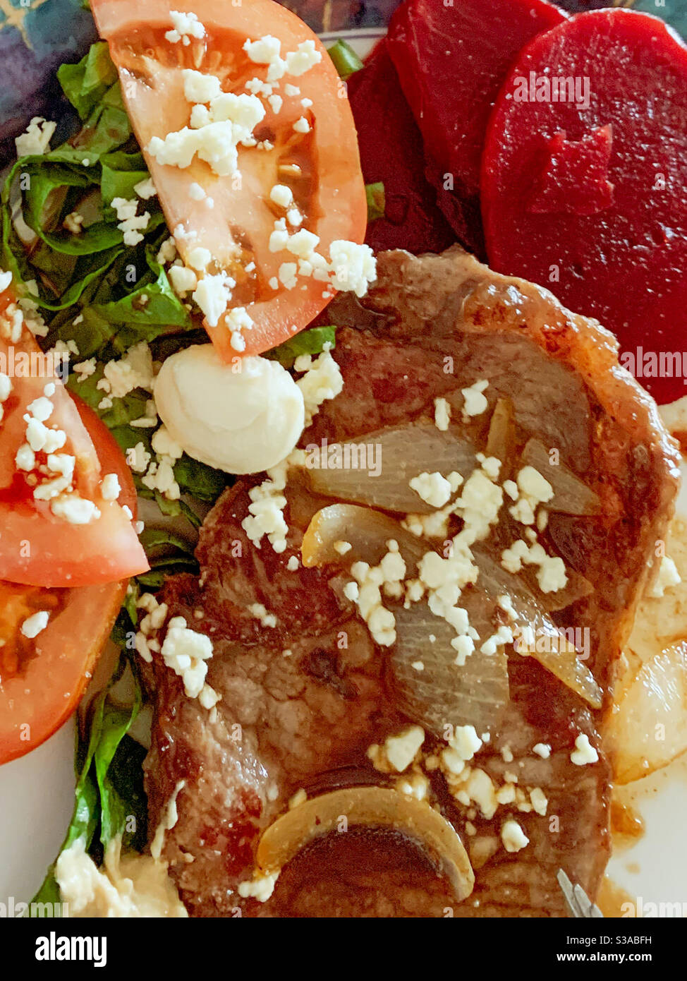 Bonne nourriture, steak, oignon et dîner de salade, avec tomate, fromage feta et betterave, un repas équilibré et une alimentation saine, bien manger Banque D'Images