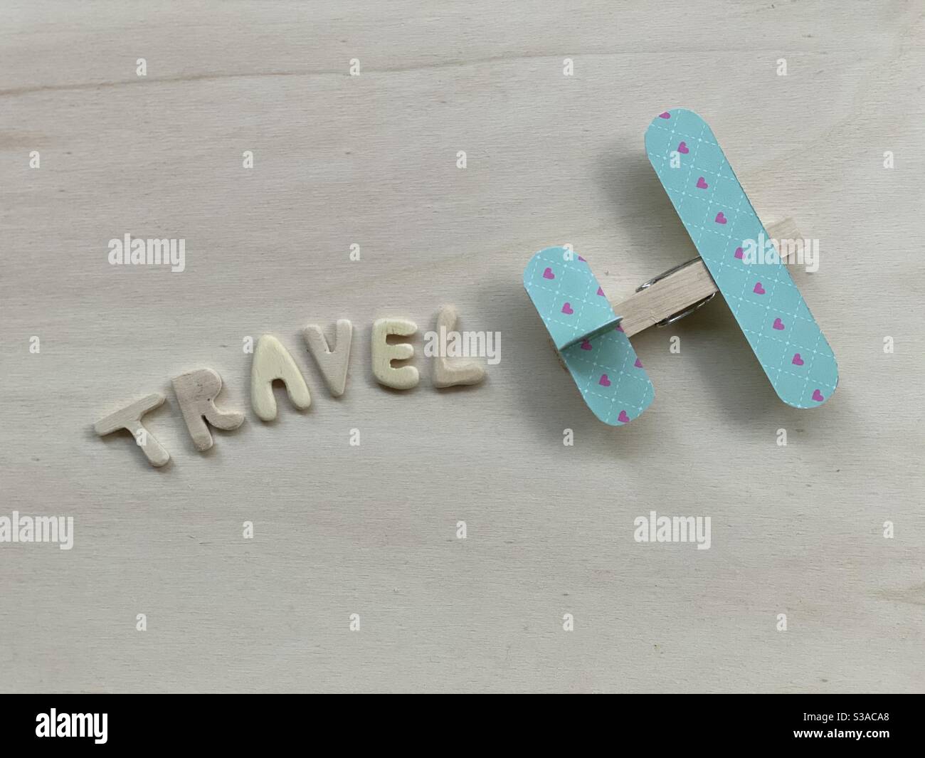Voyage, composition conceptuelle avec des lettres faites à la main en bois et un avion à épingles Banque D'Images