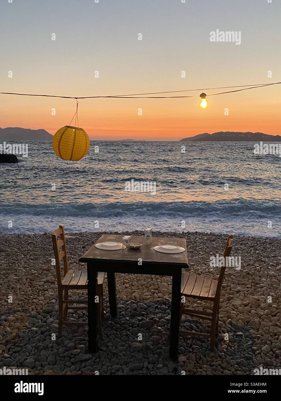 Dîner romantique sur la plage au coucher du soleil Banque D'Images