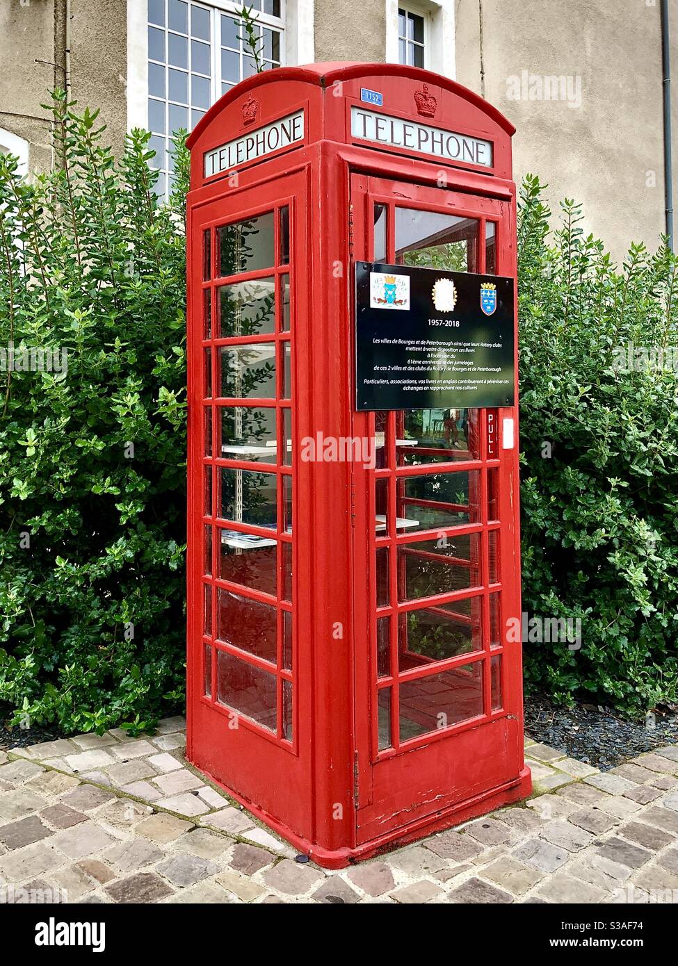 Téléphone rouge britannique converti en bibliothèque publique gratuite installée à Bourges, cher, France pour célébrer le « jumelage » avec Peterborough, Royaume-Uni, depuis 1957. - Image de stock capturée avec un smartphone