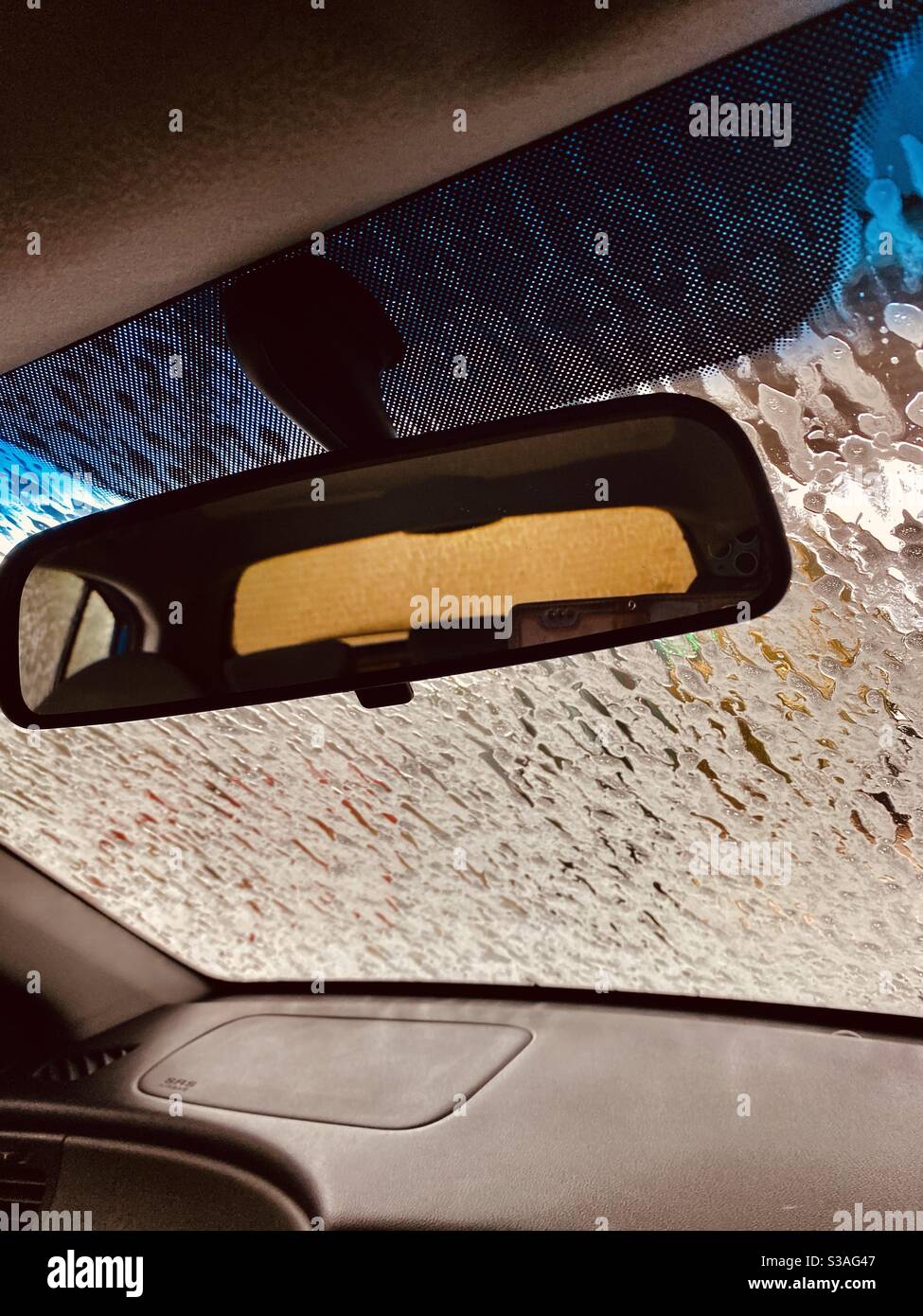 Intérieur d'une voiture dans un lavage de voiture ..tandis que la mousse sur le pare-brise nettoie. Banque D'Images