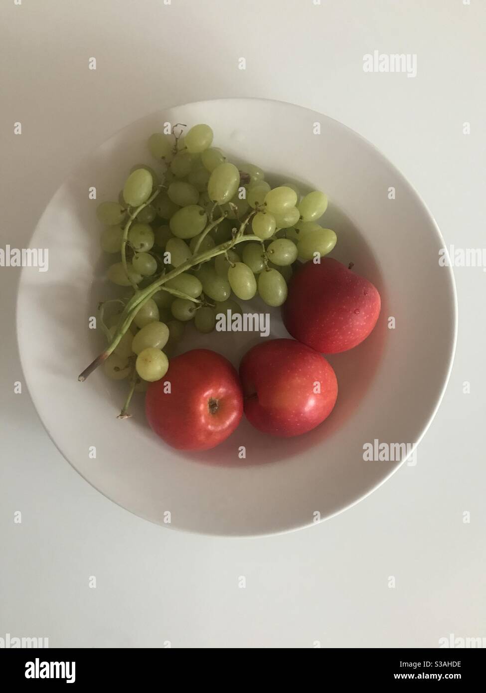 Un bol de raisins verts et de pommes rouges - Image de stock capturée avec un smartphone
