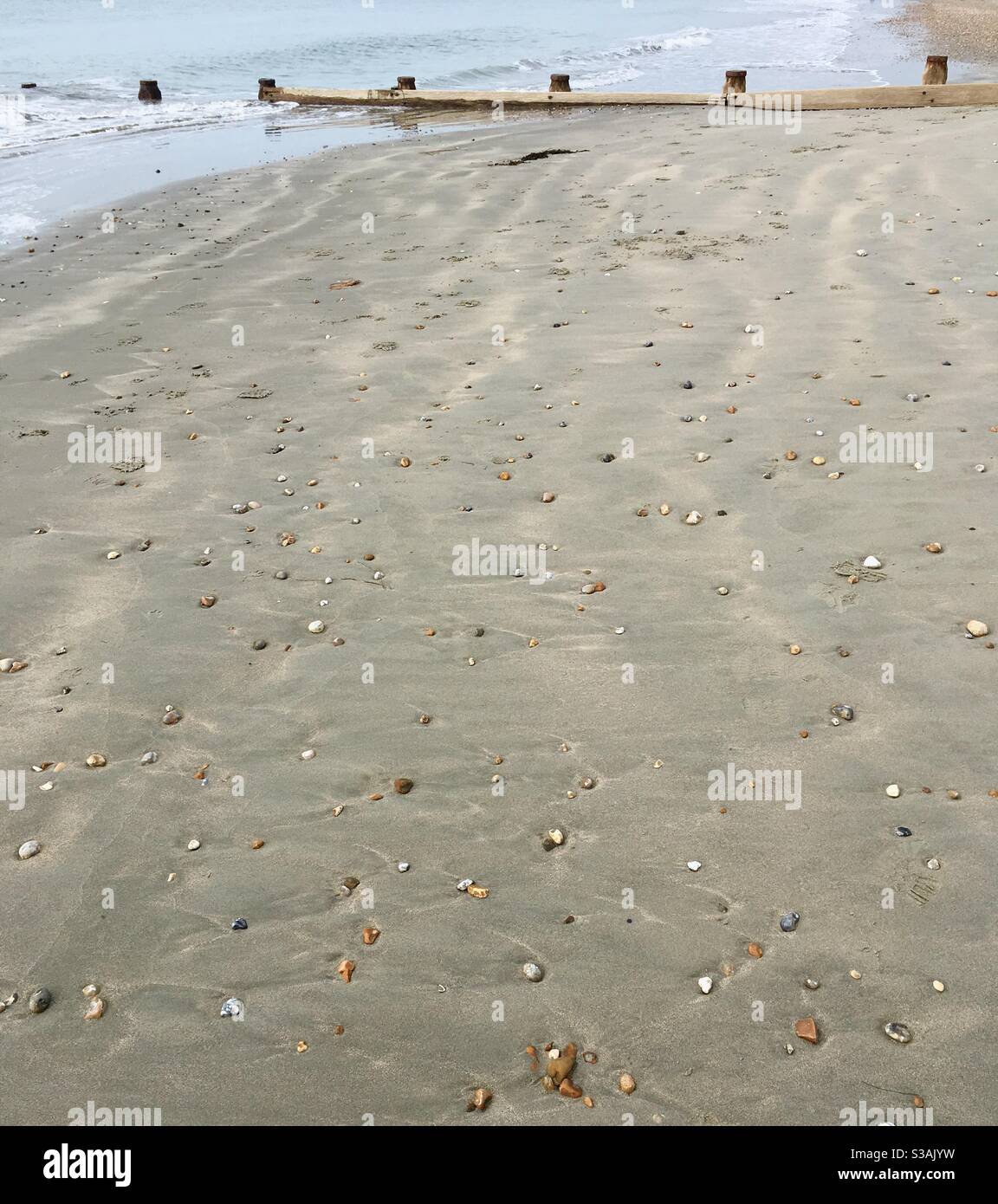 Galets parsemés sur une plage de sable - Image de stock capturée avec un smartphone