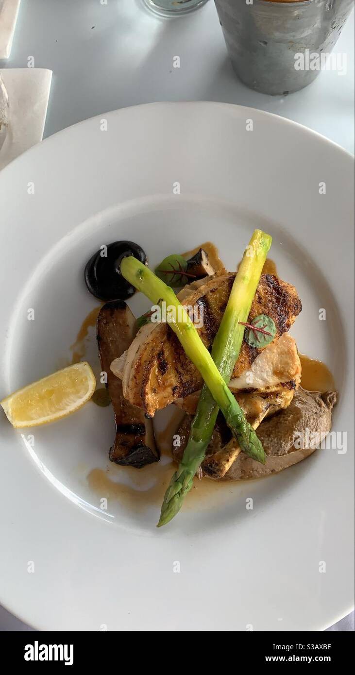 Poulet mariné au thym citronné, asperges rôties et champignons des huîtres, jus d'ail noir - Image de stock capturée avec un smartphone