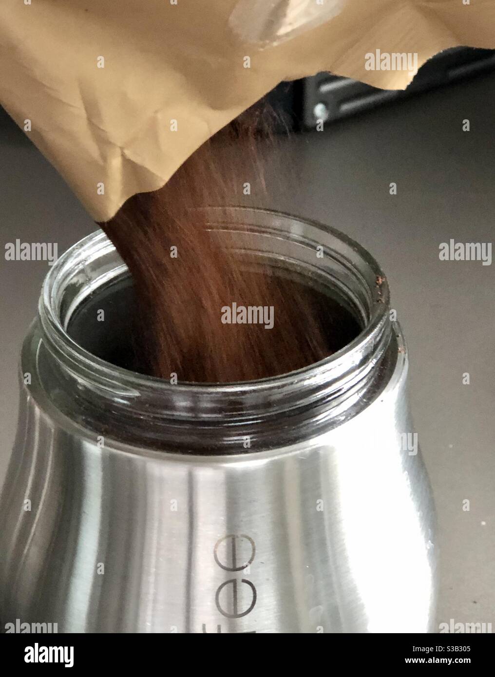 Le café moulu est versé dans un pot de conservation Photo Stock - Alamy