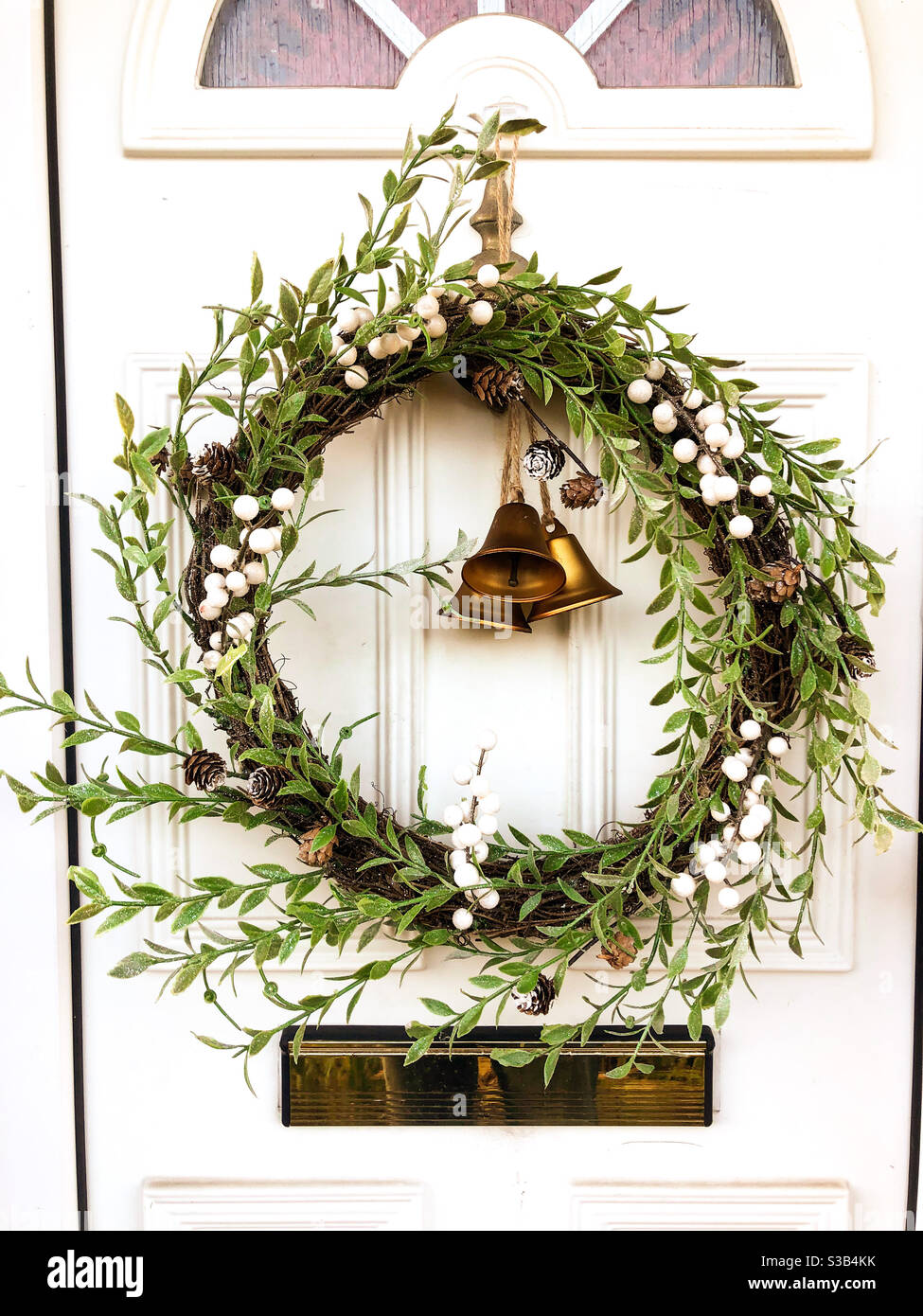Une couronne de Noël festive est suspendue par une porte d'entrée. Banque D'Images