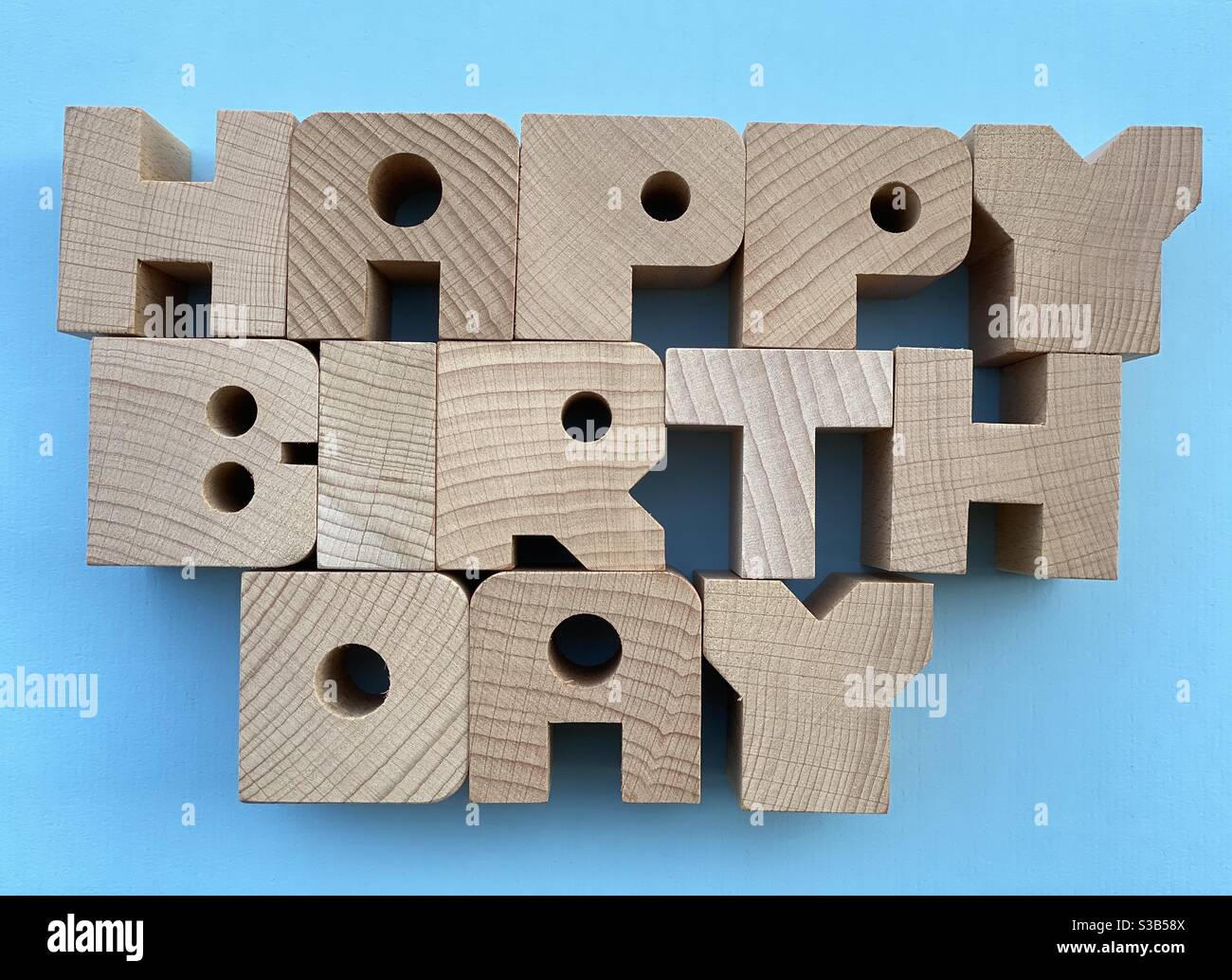 Texte joyeux anniversaire composé de lettres en bois sur fond bleu - Image de stock capturée avec un smartphone