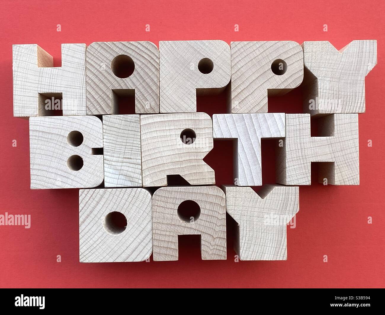 Texte joyeux anniversaire composé de lettres en bois sur fond rouge - Image de stock capturée avec un smartphone