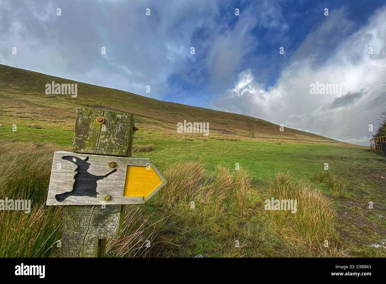 Affiche avec la silhouette de la sorcière pointant vers le chemin vers le haut Pendle Hill dans le Lancashire par une journée ensoleillée Banque D'Images