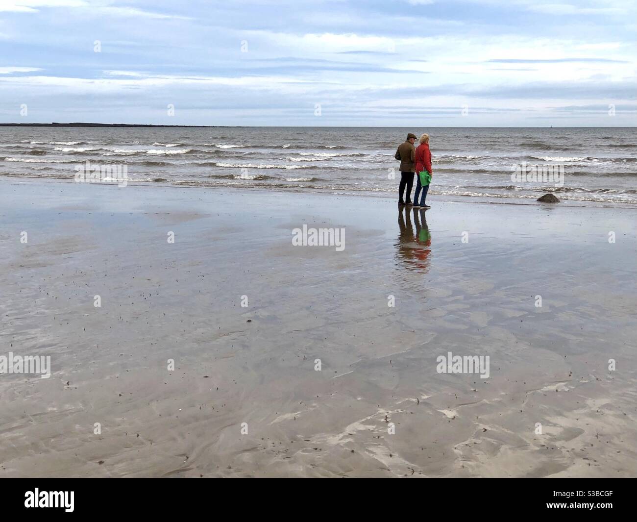 Couple debout sur la mer au bord de la vagues le jour de l'hiver - Image de stock capturée avec un smartphone