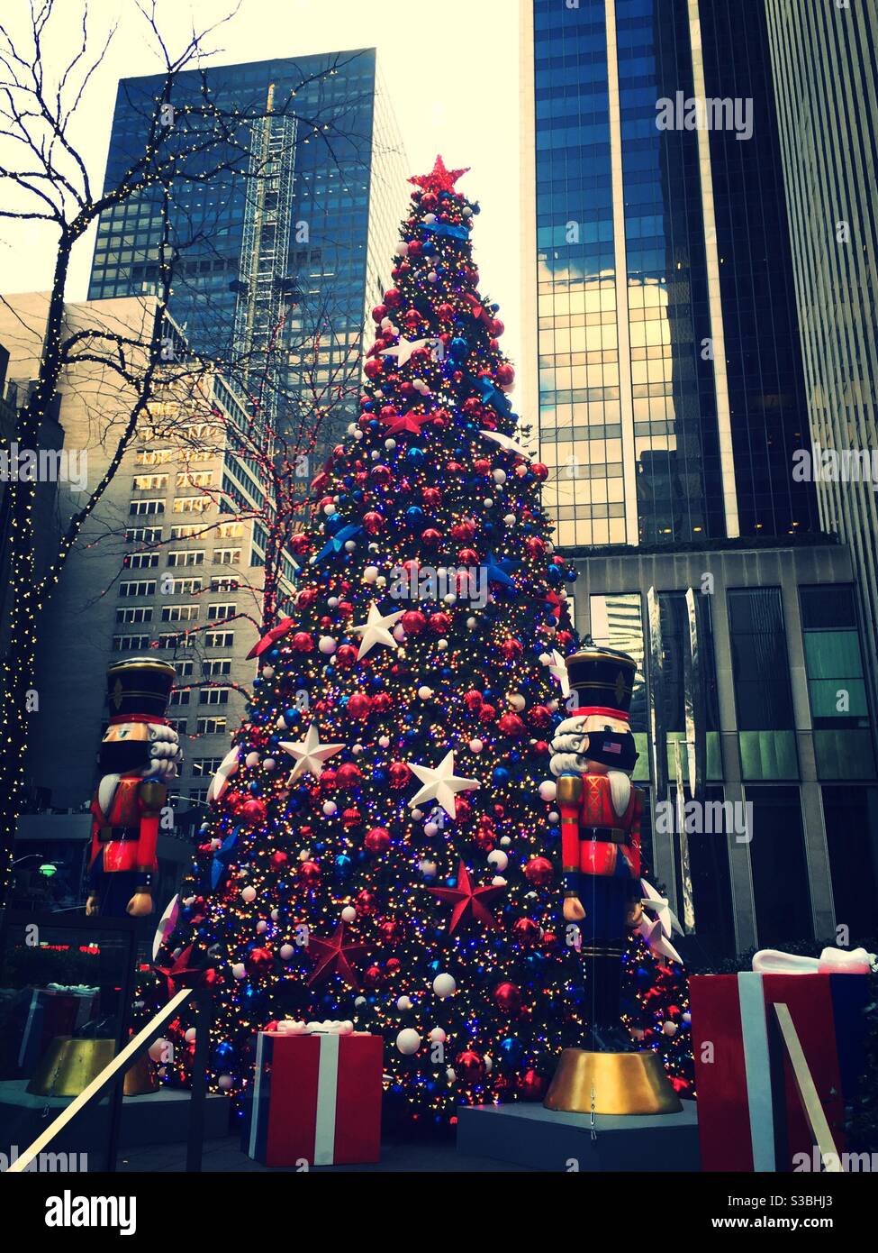 Grand arbre de Noël et exposition de vacances avec des cadeaux et des statues de casse-noisette à Fox Corner, Avenue the Americas, NYC, USA - Image de stock capturée avec un smartphone