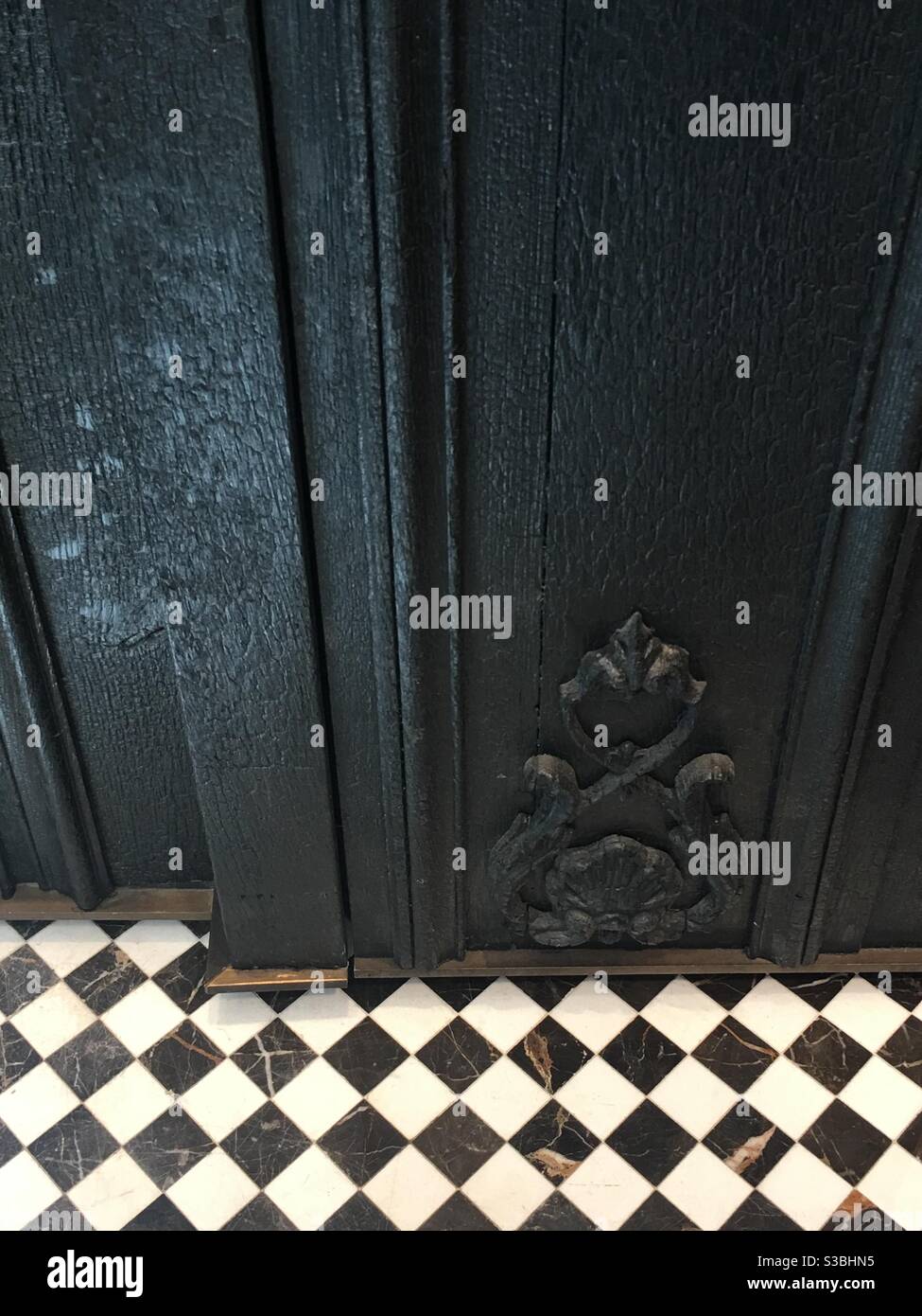 Porte texturée noire avec plancher à carreaux Banque D'Images