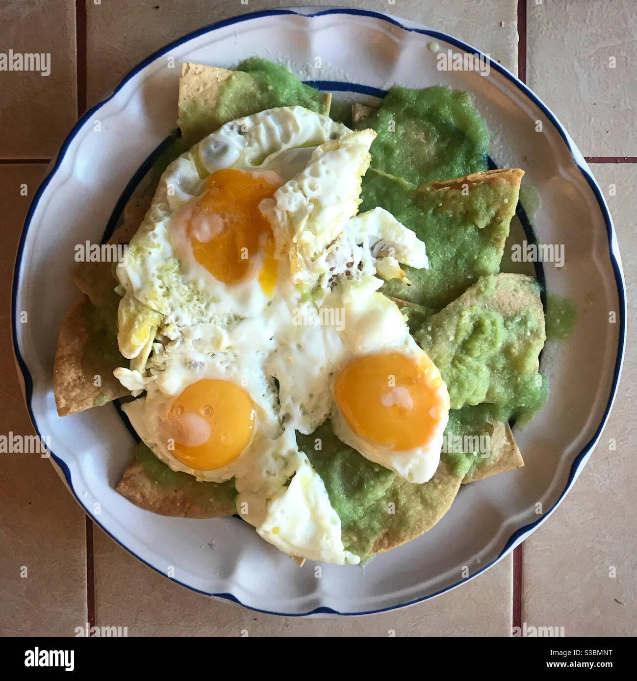 Petit déjeuner de maïs à la sauce verte avec trois œufs frits ou «huevos estrellados» à Queretaro, au Mexique Banque D'Images