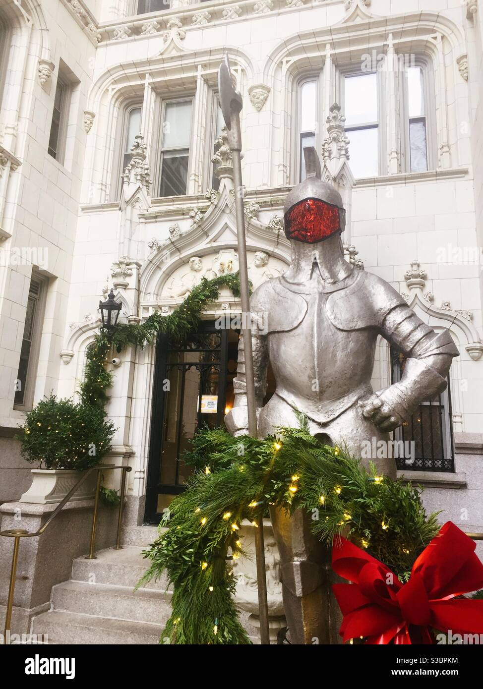 Une statue d'un chevalier blindé se dresse devant un immeuble de luxe haut de gamme à Gramercy Park pendant la période des fêtes, NYC, Etats-Unis Banque D'Images