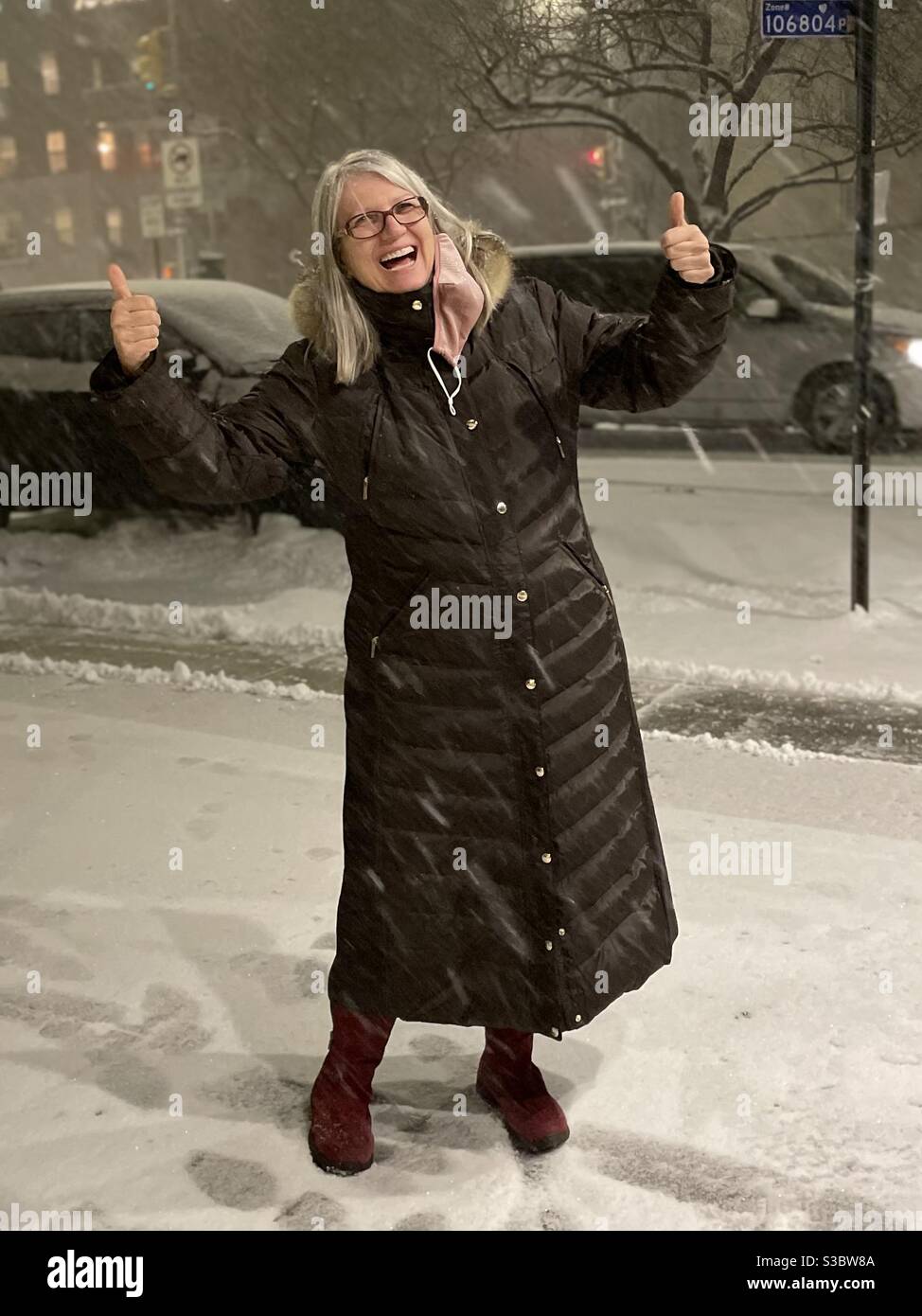 C'est le temps de neige!! Femme enchantée de la première grande neige de la saison à Manhattan. Banque D'Images