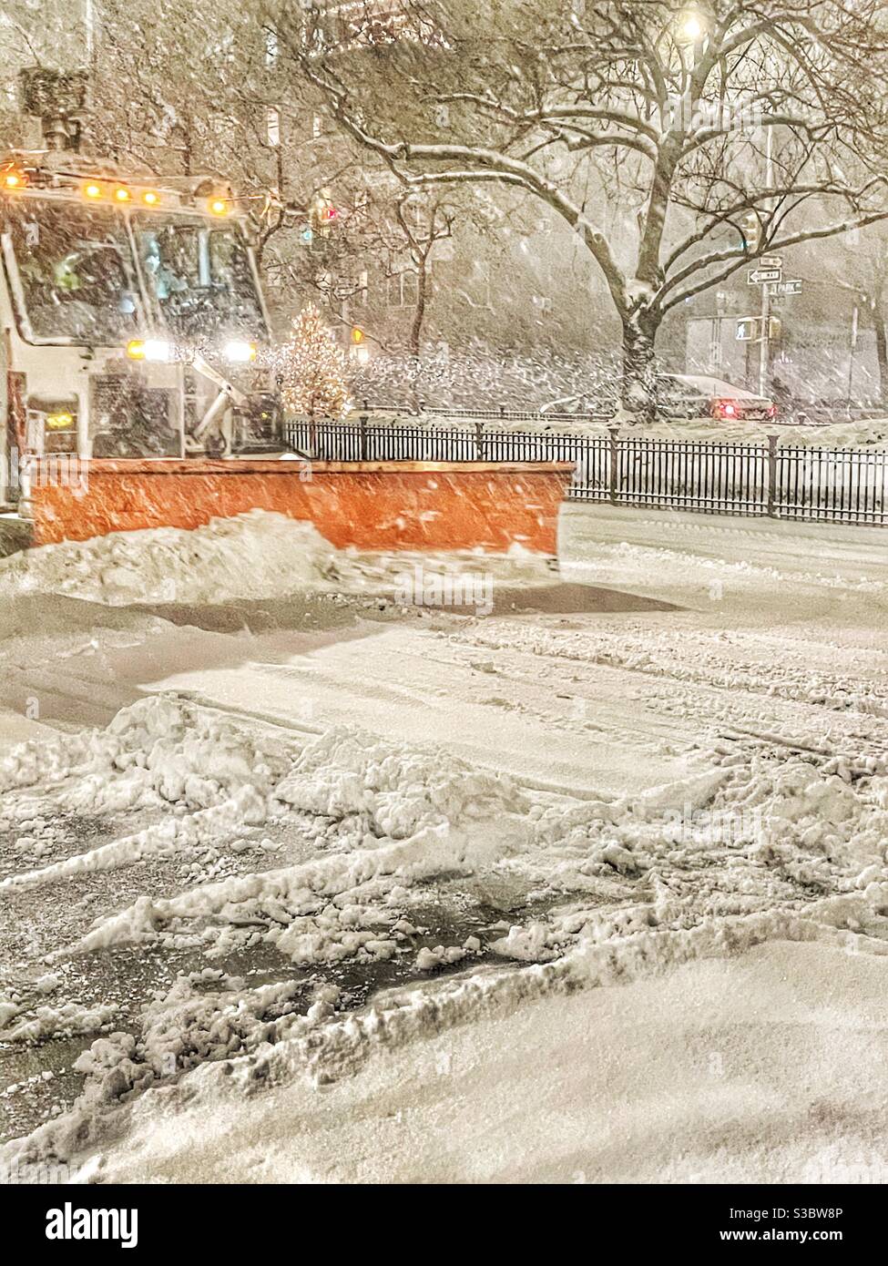 Chasse-neige rouge défrichant la rue de Park Avenue à la 36e rue alors que la neige tombe à NewYork. Banque D'Images