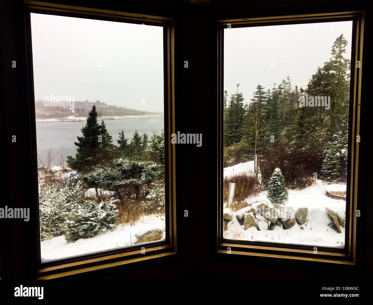 La neige grince sur l'océan. Une froide journée d’hiver, Halifax, Nouvelle-Écosse, Canada. Vue donnant sur l'intérieur d'un cottage confortable. Banque D'Images