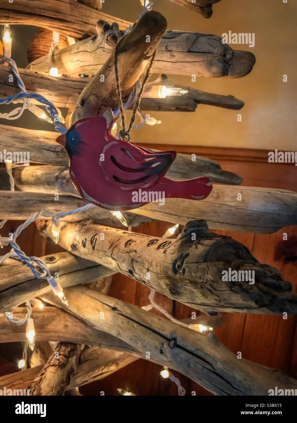 Cardinal rouge en bois suspendu sur un arbre de Noël en bois flotté de couleur blanche feux Banque D'Images
