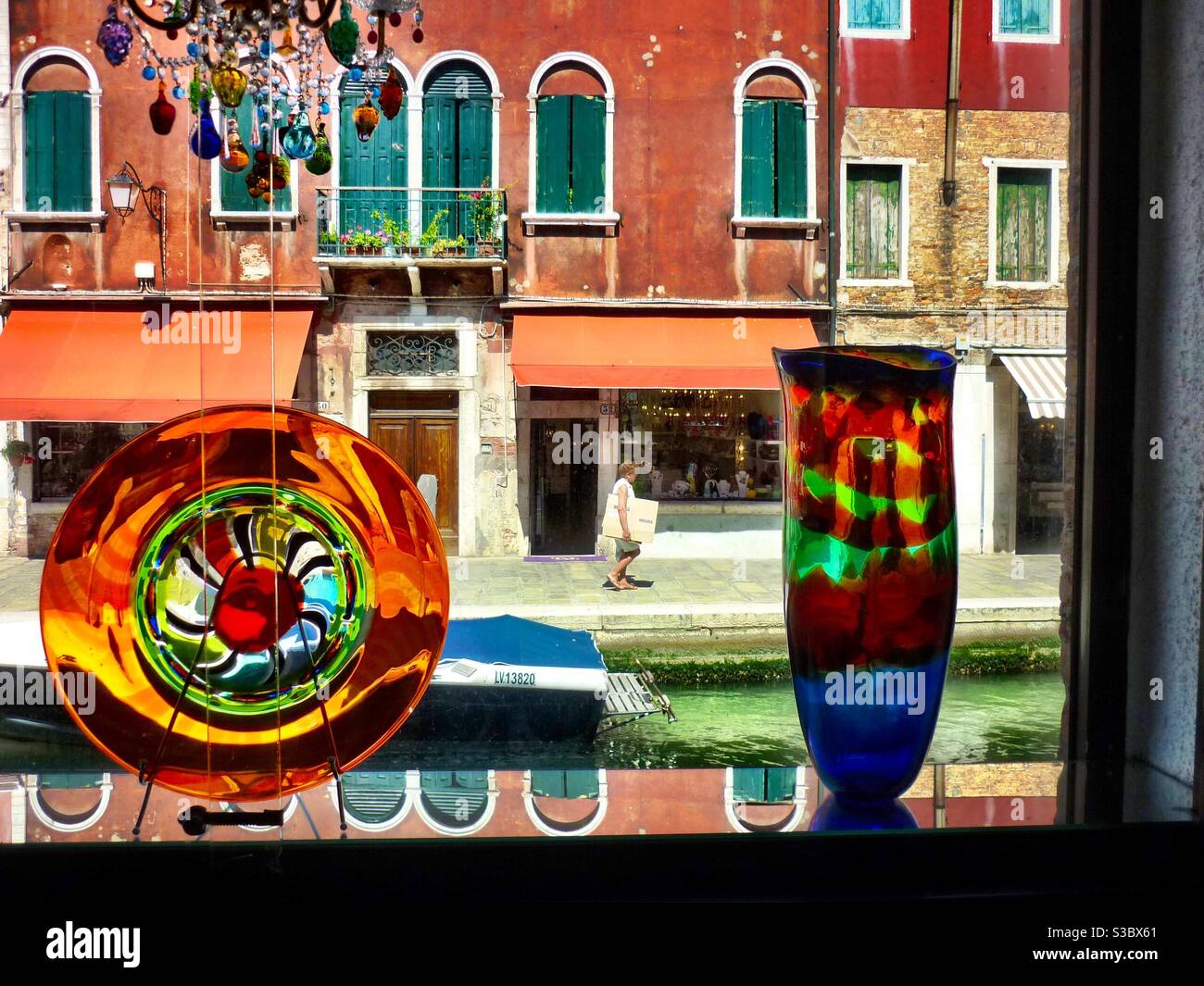 Assiette en verre de Murano et vase colorés sur une fenêtre Venise Banque D'Images