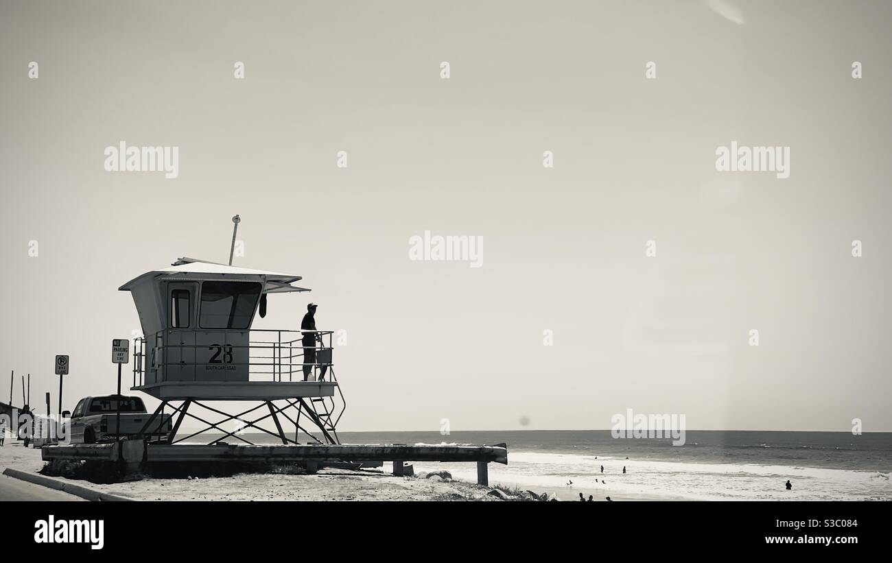 CARLSBAD, CA, AOÛT 2020 : montres de vigile silhoueté baigneurs et surfeurs dans l'océan Pacifique, de la hutte à côté de la Pacific Coast Highway pendant la pandémie de Covid-19. Noir et blanc Banque D'Images CARLSBAD, CA, AOÛT 2020 : montres de vigile silhoueté baigneurs et surfeurs dans l'océan Pacifique, de la hutte à côté de la Pacific Coast Highway pendant la pandémie de Covid-19. Noir et blanc Banque D'Images