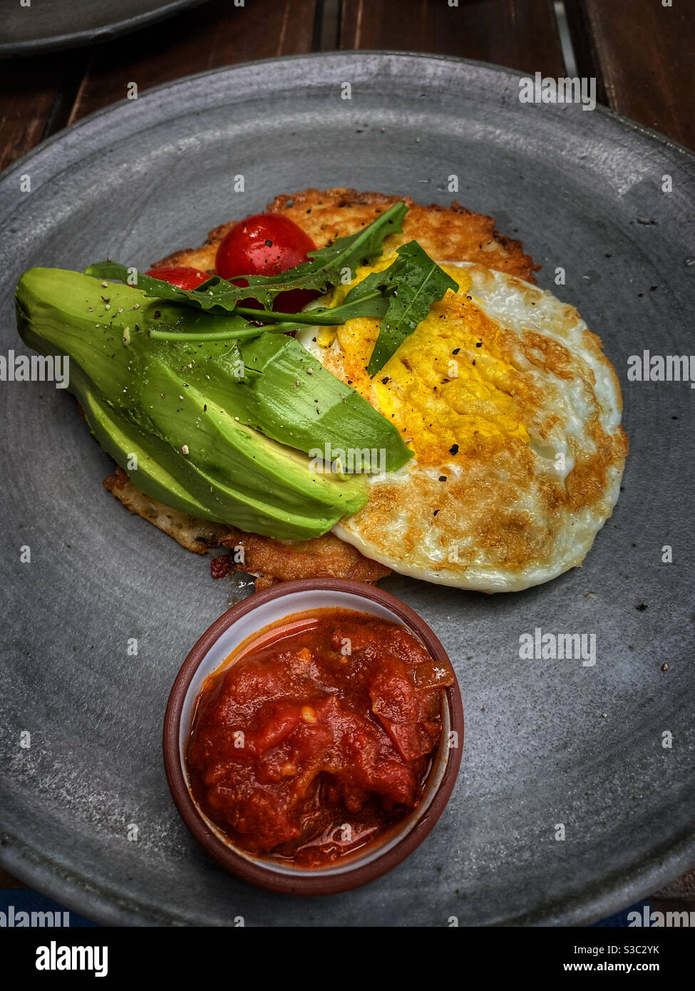 Petit-déjeuner composé d'œufs, d'avocats et de rösti. Banque D'Images