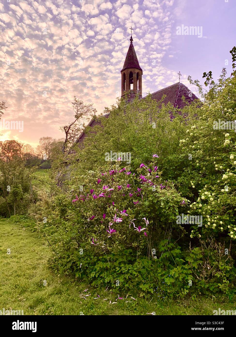 Petite église gothique victorienne anglaise avec jardin de chalet surcultivé au coucher du soleil Somerset, Angleterre, mai 2020 Banque D'Images