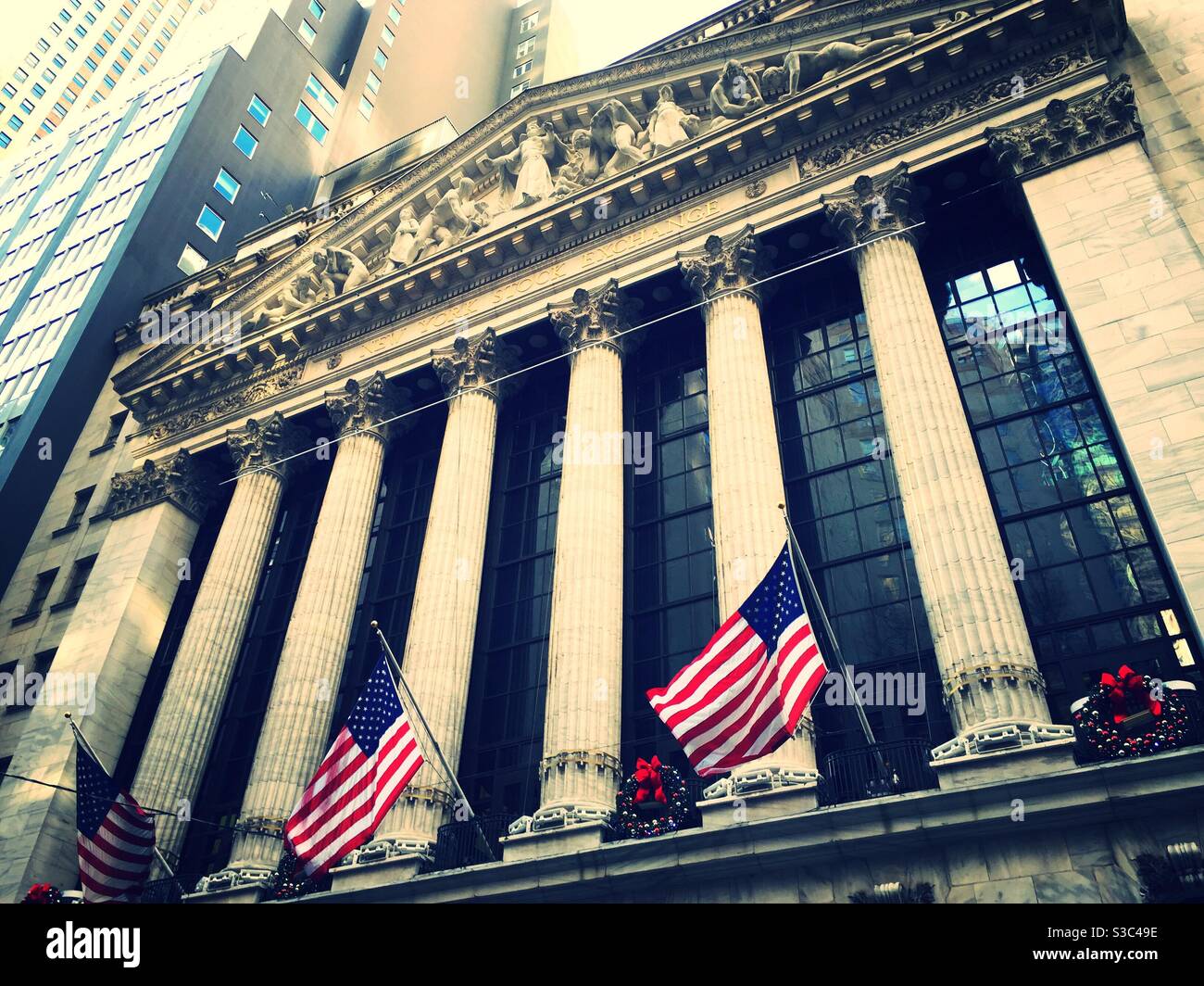 La bourse de New York place des couronnes de fête sur ses colonnes pendant la période des fêtes, NYC, USA - Image de stock capturée avec un smartphone