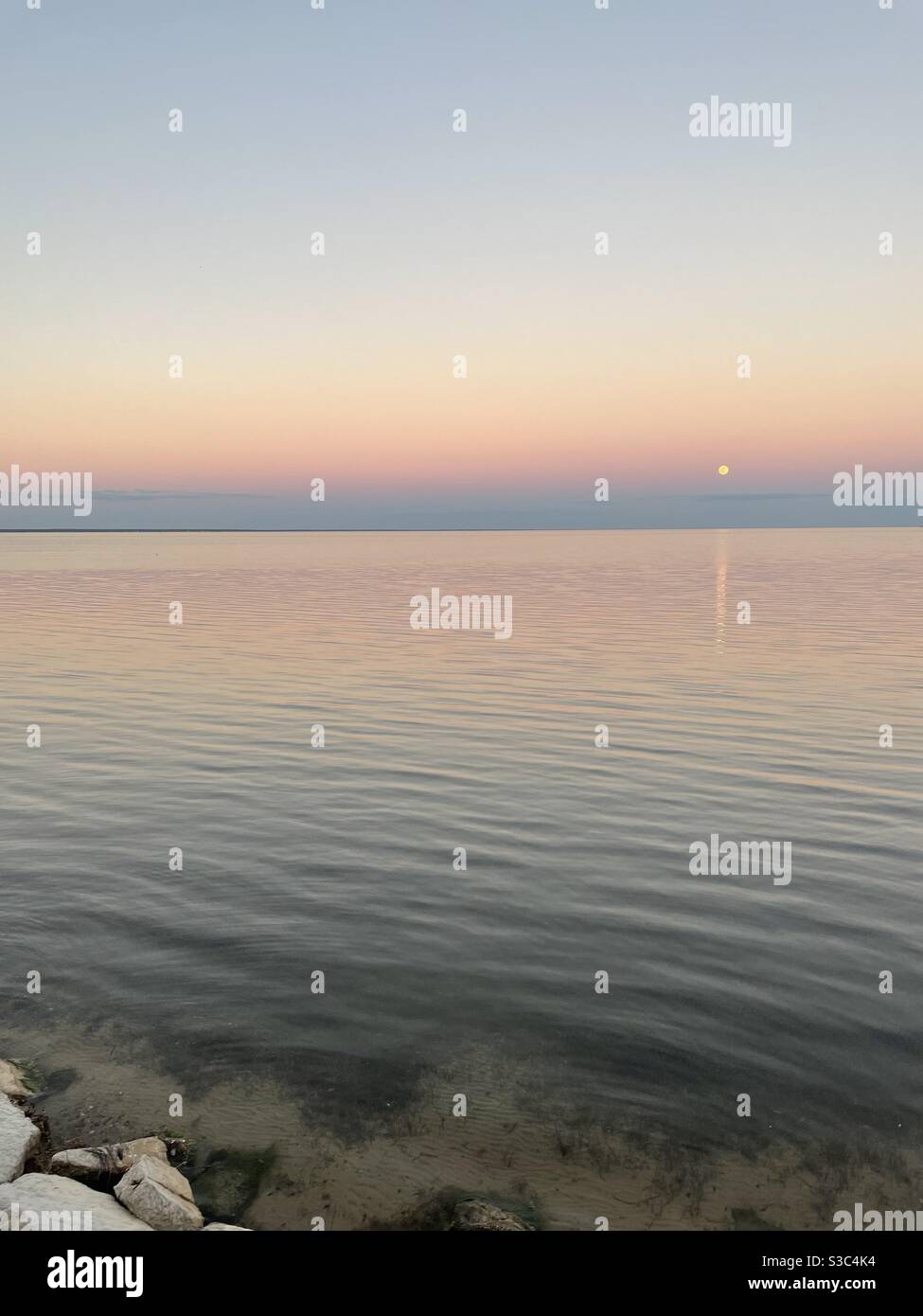 Dernière pleine lune de 2020 avec coucher de soleil sur la baie eau Banque D'Images