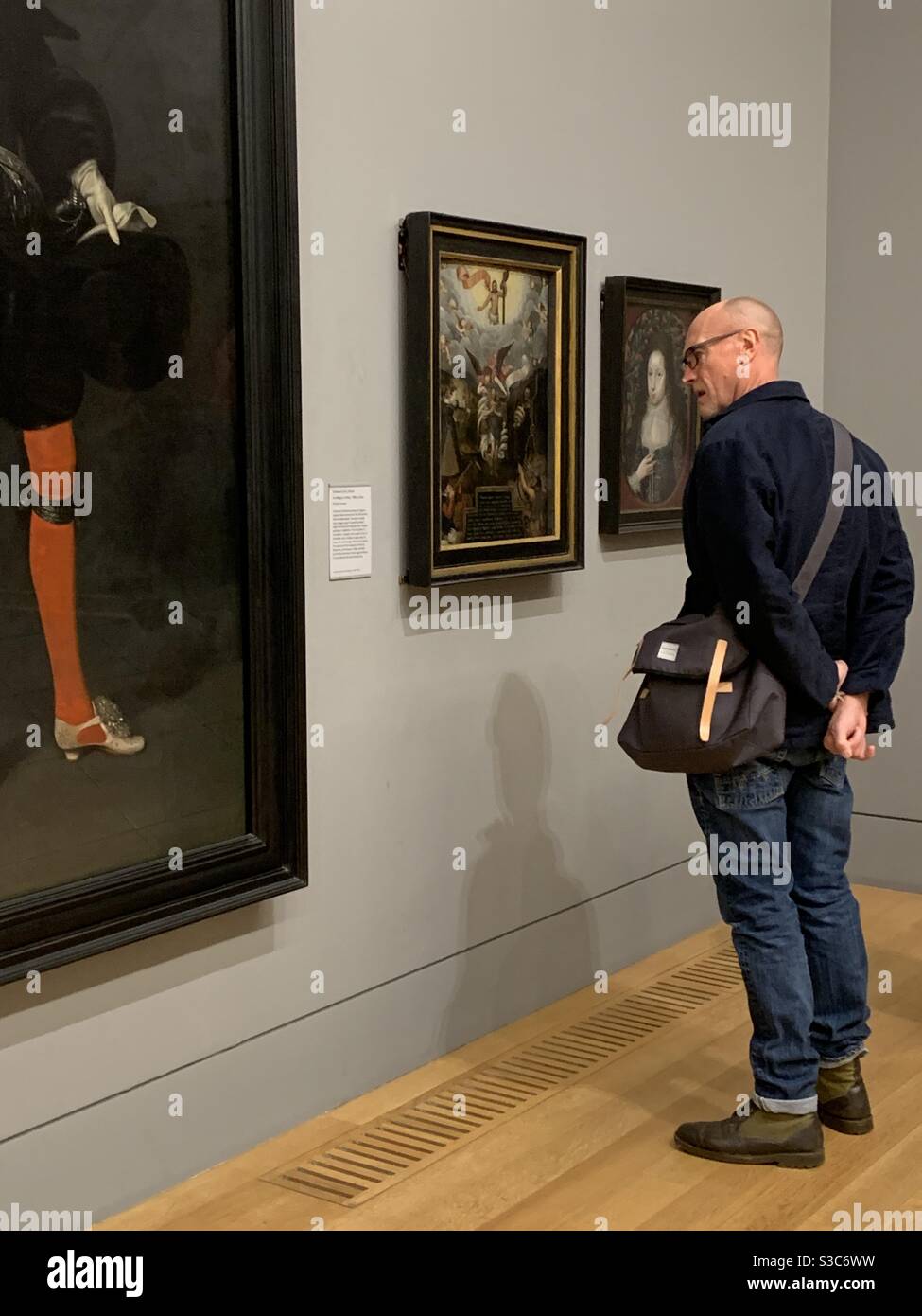 Beau homme au Tate Britain portant une veste noire, des lunettes et un Jean, qui apprécie l'art et la culture. Banque D'Images