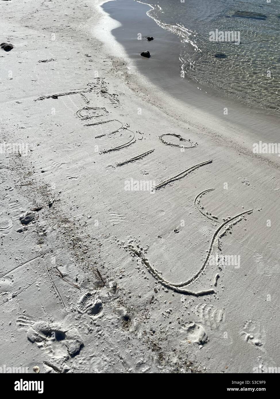 Famille écrite dans le sable sur la plage Banque D'Images