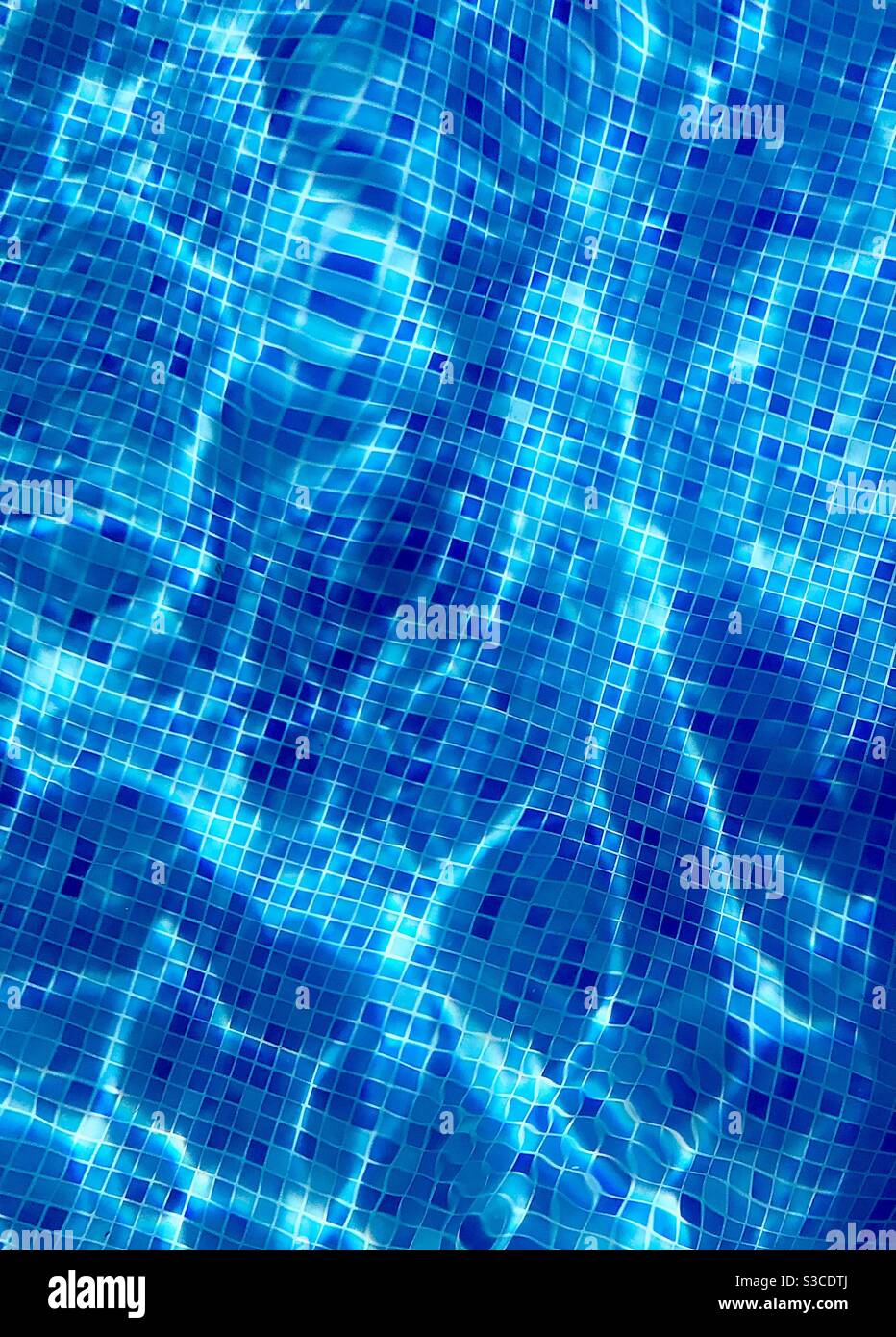 Bleu aigue-marine du fond de la piscine, carreaux de bisazza réfractés par l'eau et les vagues Banque D'Images