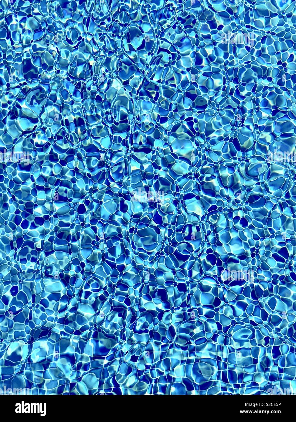 Carreaux de piscine bisazza carrés bleu vif gauchis et réfractés une piscine privée en été soleil en vacances En Turquie Banque D'Images