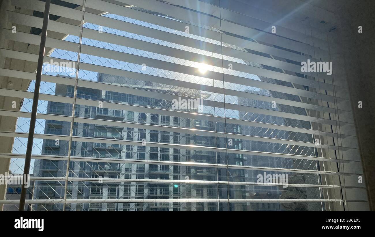 LOS ANGELES, CA, SEP 2020: Nouveau centre résidentiel avec le soleil en vue, vu à travers les stores vénitiens et le verre de sécurité d'un ancien bâtiment - Image de stock capturée avec un smartphone