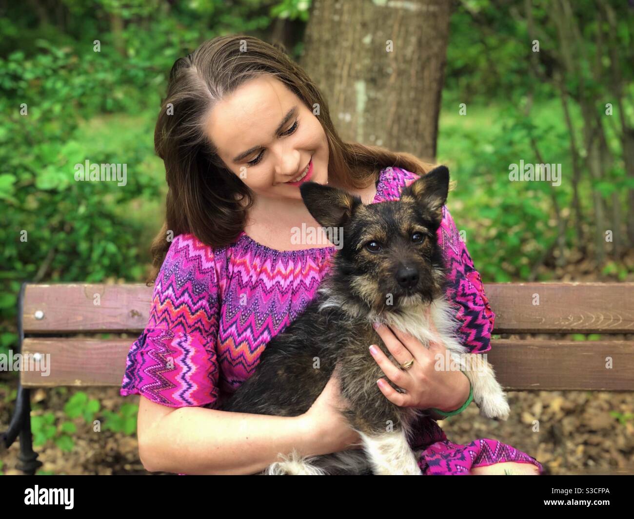 Jeune femme avec un petit chien sur ses genoux - Image de stock capturée avec un smartphone