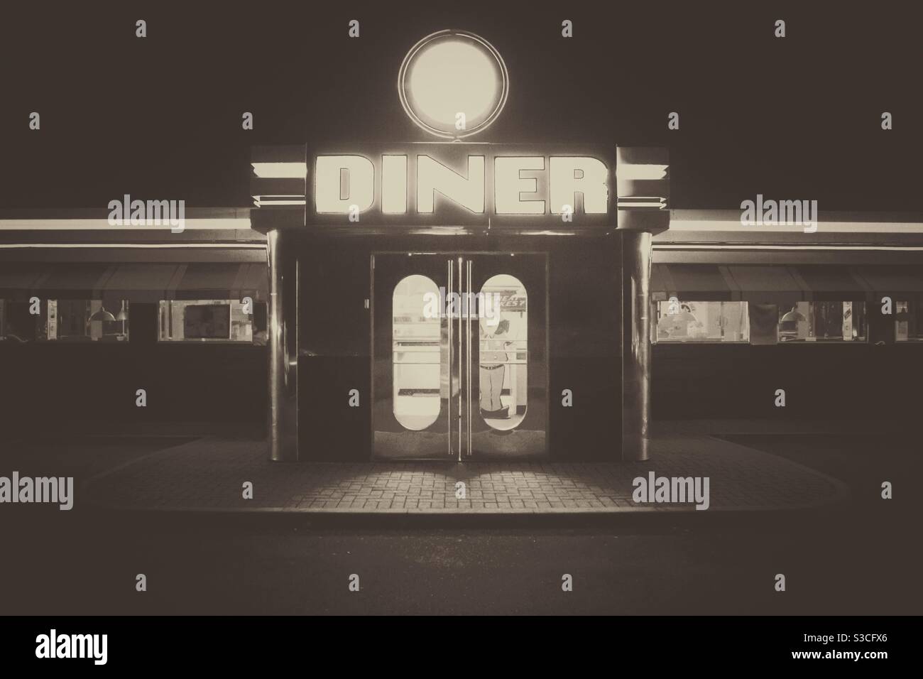 Un restaurant américain à l'ancienne en noir et blanc avec des lumières vives à nuit - Image de stock capturée avec un smartphone