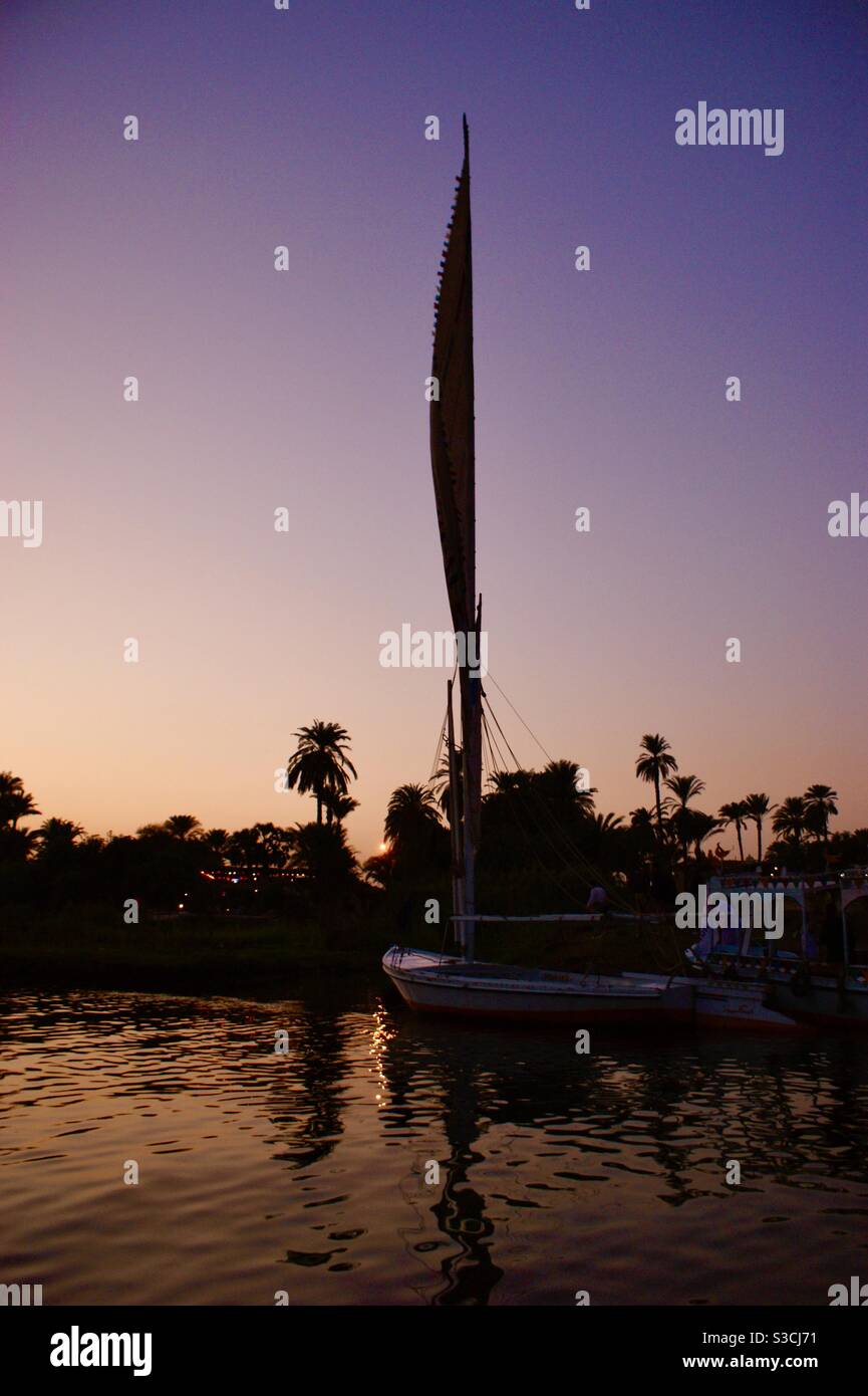 Magnifique et élégant felucca bateau traditionnel naviguant sur le Nil au coucher du soleil près de Louxor, Egypte Banque D'Images