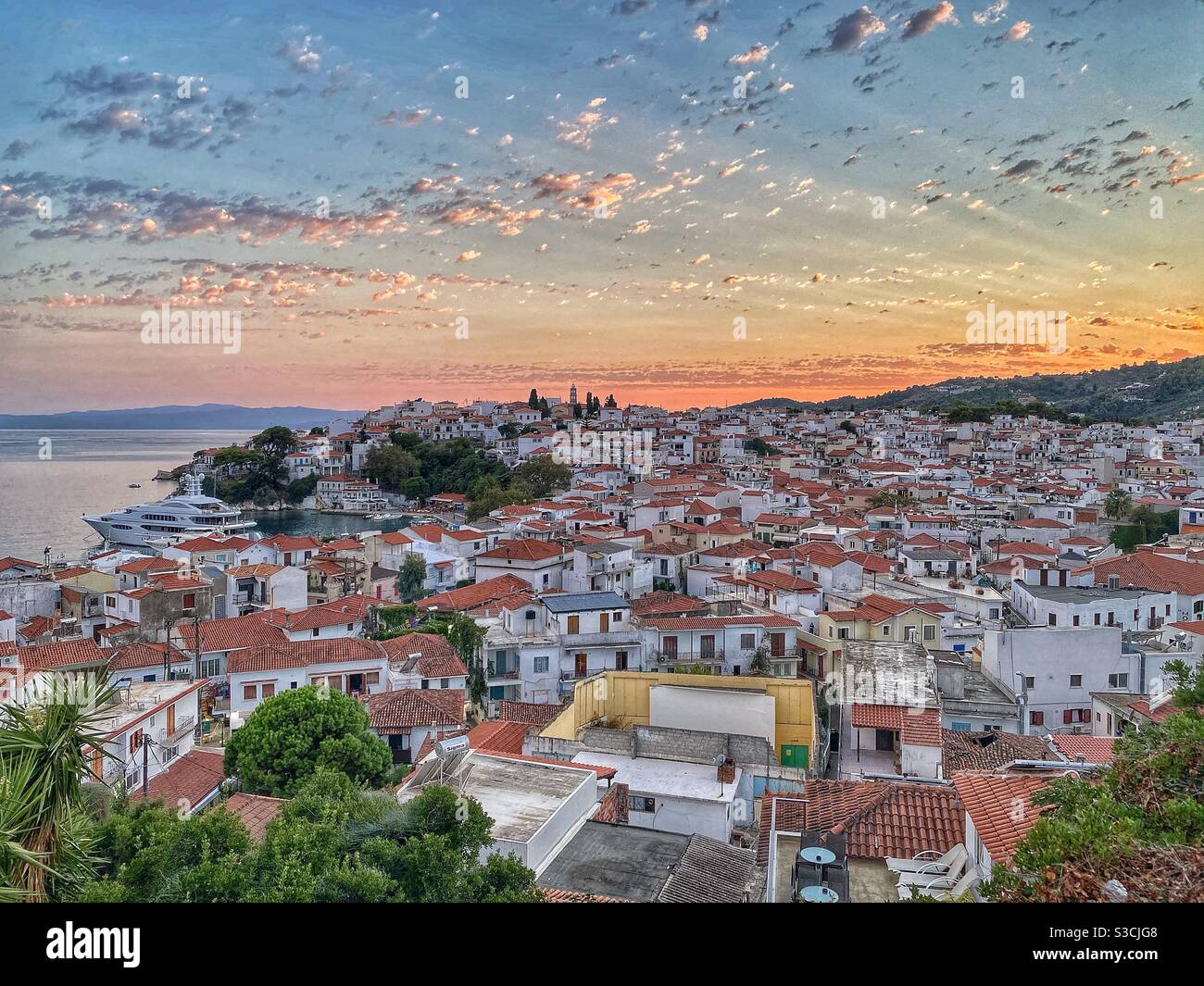 Vue sur le coucher du soleil à Skiathos ville avec port de l'église Saint-Nicolas, Grèce. - Image de stock capturée avec un smartphone