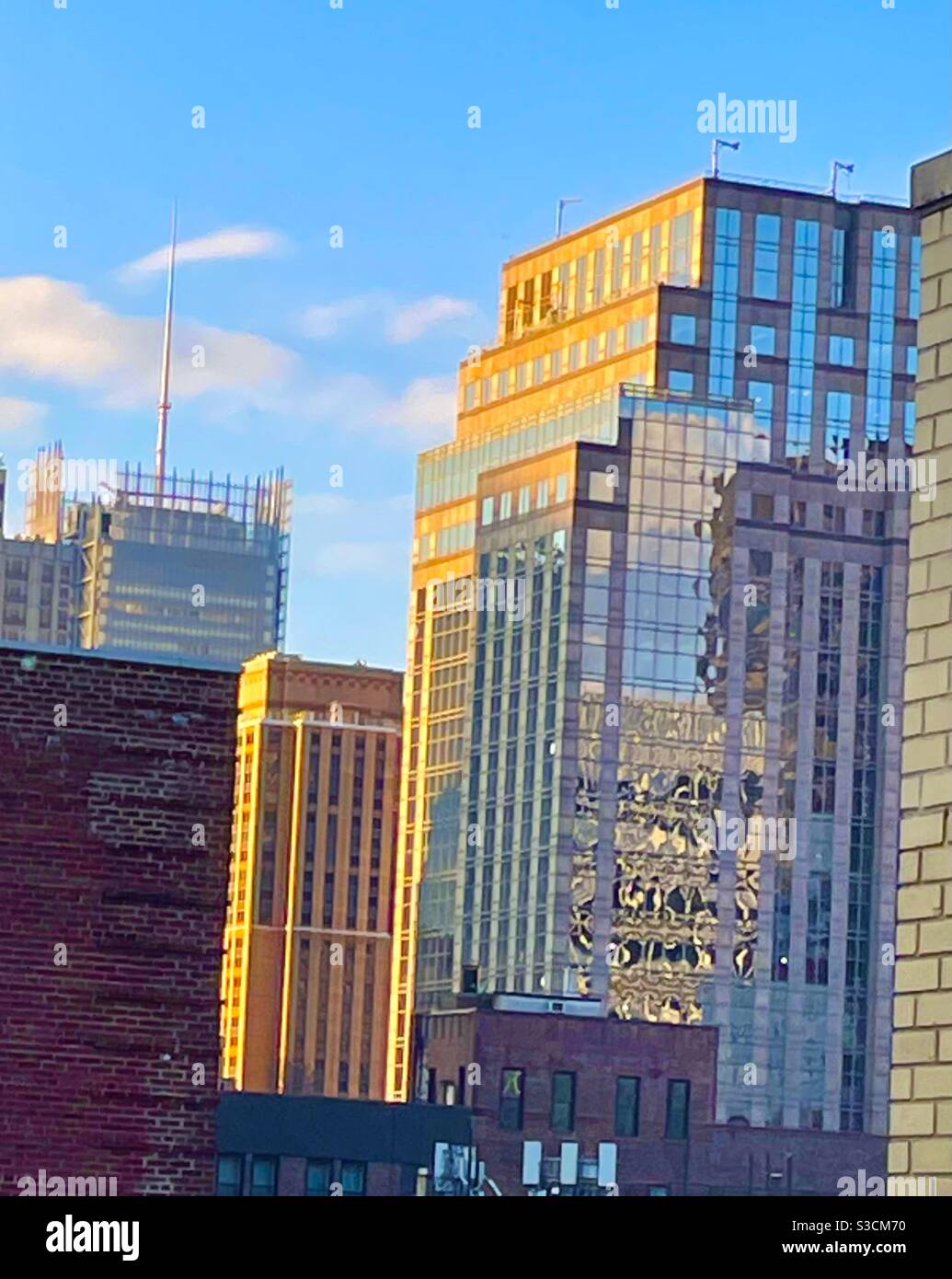 Le soleil de fin d'après-midi brille magnifiquement sur les gratte-ciel dedans Midtown Manhattan créant des réflexions intéressantes sur les fenêtres en verre - Image de stock capturée avec un smartphone