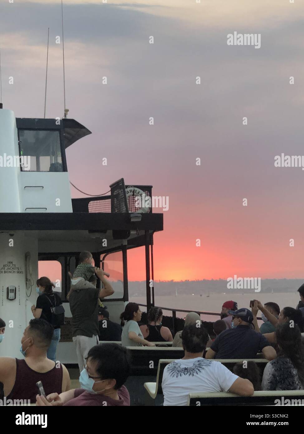 Les passagers sur une croisière Hornblower port bateau de Du centre-ville de San Diego à Coronado Island ont une vue magnifique D'un coucher de soleil rouge brillant causé par la fumée de la beaucoup de feux dedans - Image de stock capturée avec un smartphone
