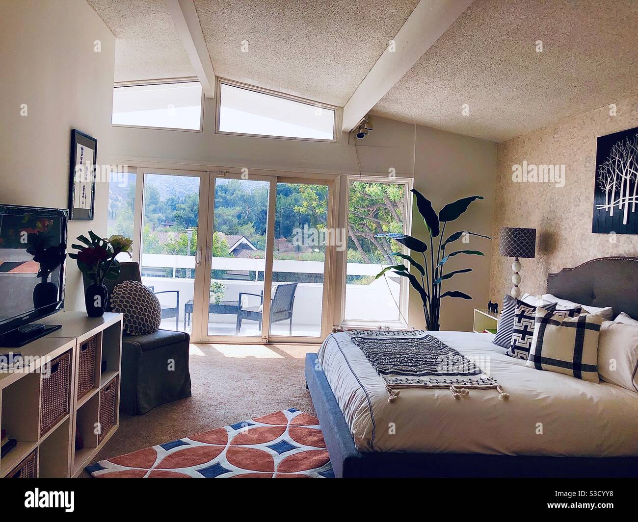 Une maison américaine classique du milieu du siècle moderne avec d'immenses fenêtres, porte vitrée coulissante sur un balcon de la chambre et poutres apparentes est conçue simplement pour présenter l'impressionnante vue sur la colline en Californie. - Image de stock capturée avec un smartphone