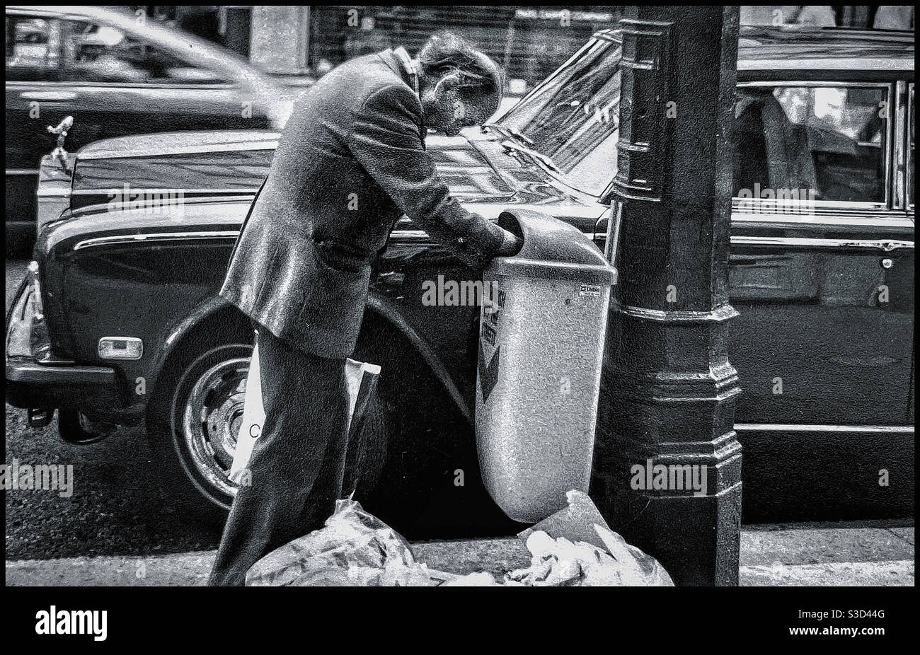 Un homme s'enracine dans un casier à ordures à Londres Banque D'Images