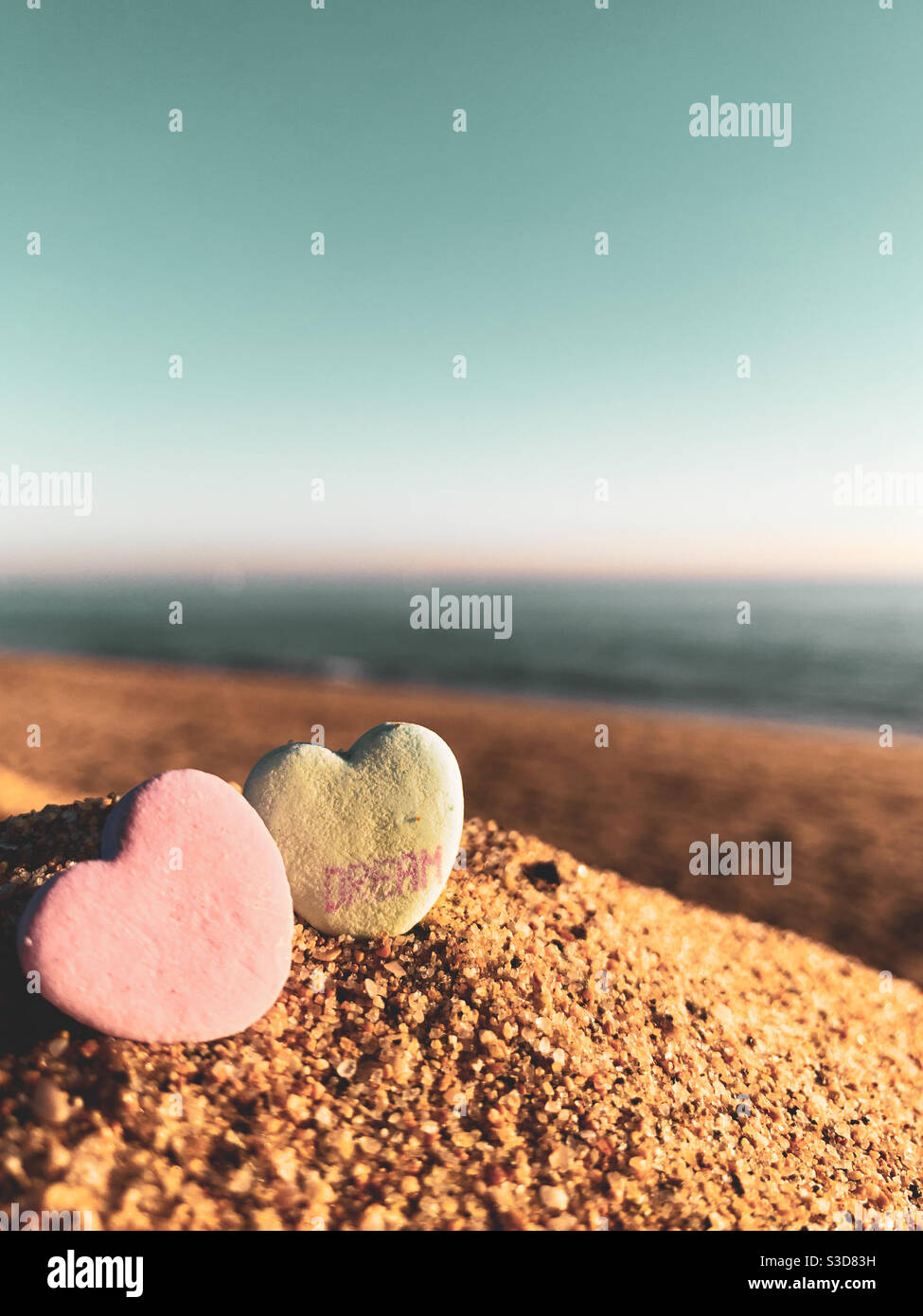 Vue en angle bas de deux cœurs de bonbons sur une plage Banque D'Images