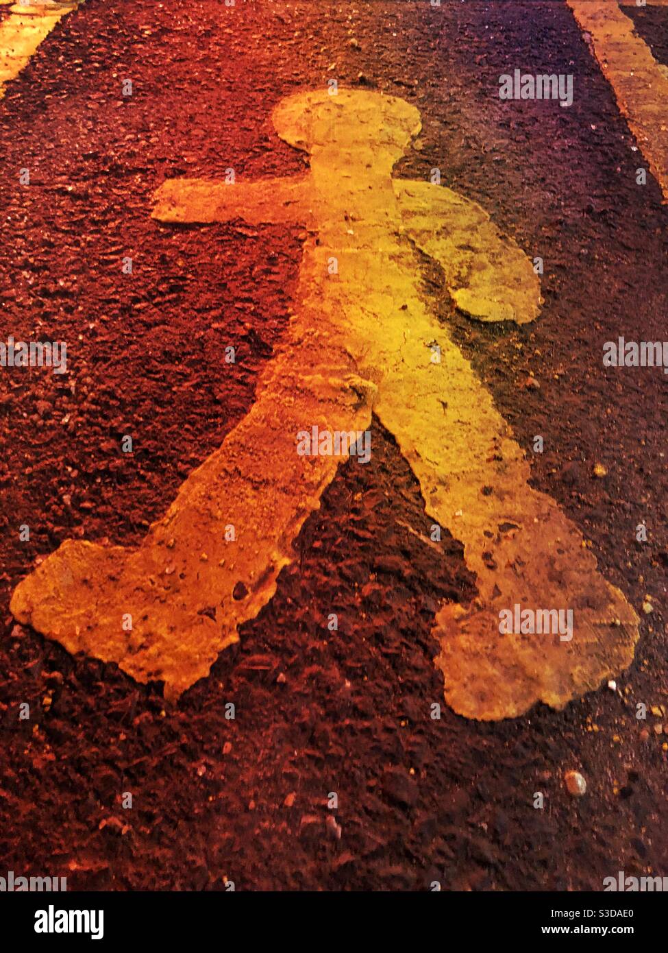 Un homme peint sur le trottoir avec de la peinture jaune représentation de forme humaine au sol - Image de stock capturée avec un smartphone