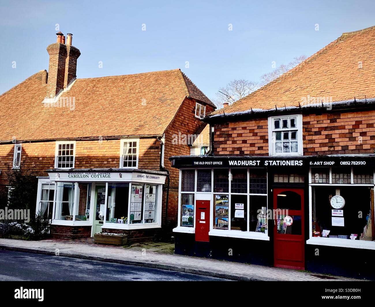 Magasins typiques du vieux village et le vieux bureau de poste avec boîte postale rouge et porte rouge dans le village de Wadhurst East Sussex Royaume-Uni Banque D'Images